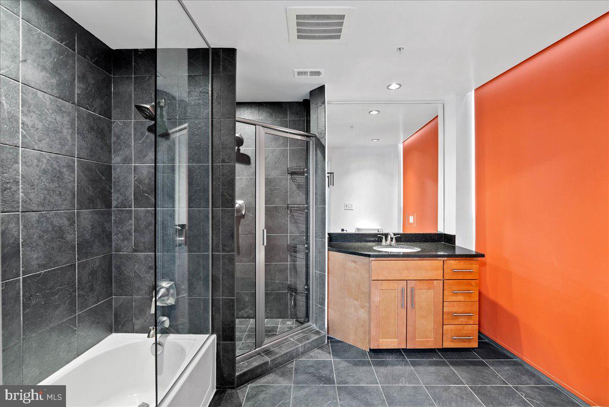 3409 Wilson Boulevard, Unit 412 Arlington, VA 22201 - Photo 18 of 19 a bathroom with a granite countertop sink a toilet and shower