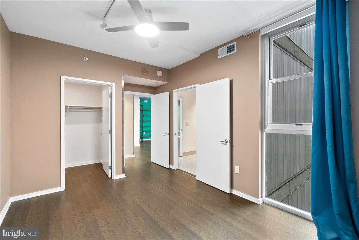 3409 Wilson Boulevard, Unit 412 Arlington, VA 22201 - Photo 5 of 19 a view of an empty room with wooden floor and a window