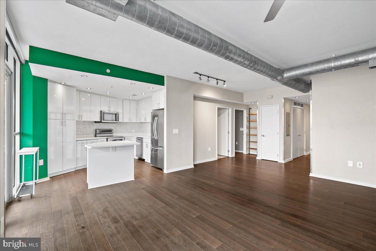 3409 Wilson Boulevard, Unit 412 Arlington, VA 22201 - Photo 9 of 19 a view of kitchen with stainless steel appliances granite countertop a refrigerator oven a sink dishwasher and white cabinets with wooden floor