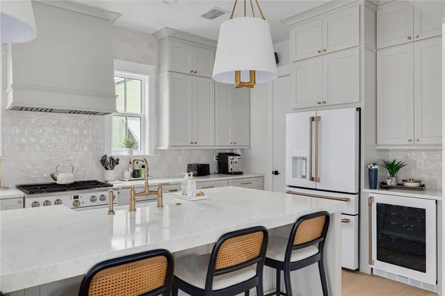 a kitchen with stainless steel appliances a stove a sink and white cabinets