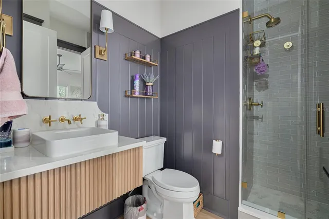 a bathroom with a sink a toilet and shower