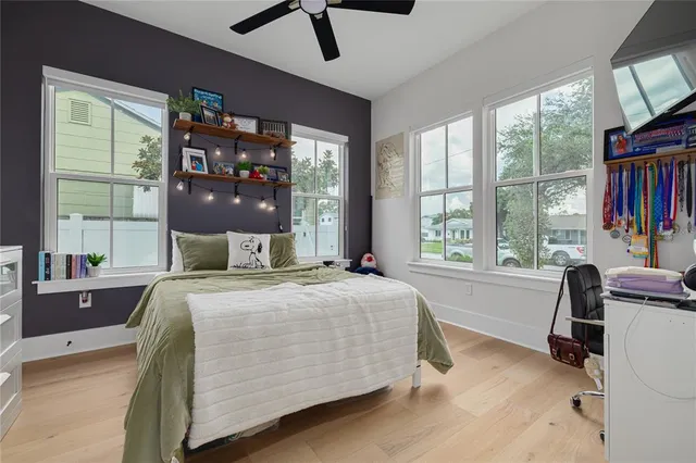 a bedroom with a bed and large windows
