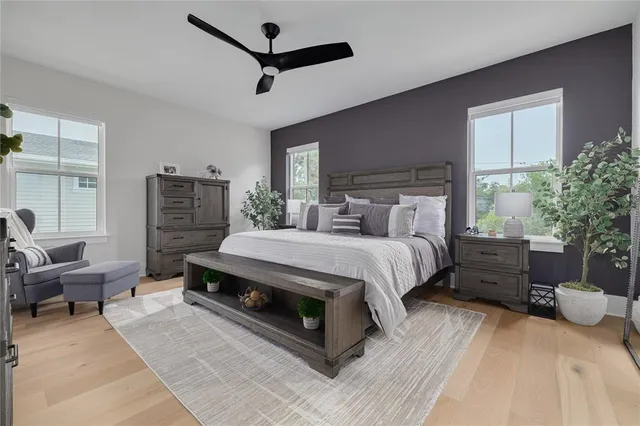 a spacious bedroom with a bed a couch and a potted plant