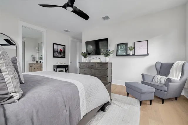 a spacious bedroom with a bed a couch and a flat screen tv