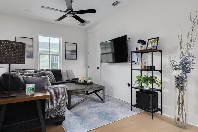 a living room with furniture a flat screen tv and a potted plant