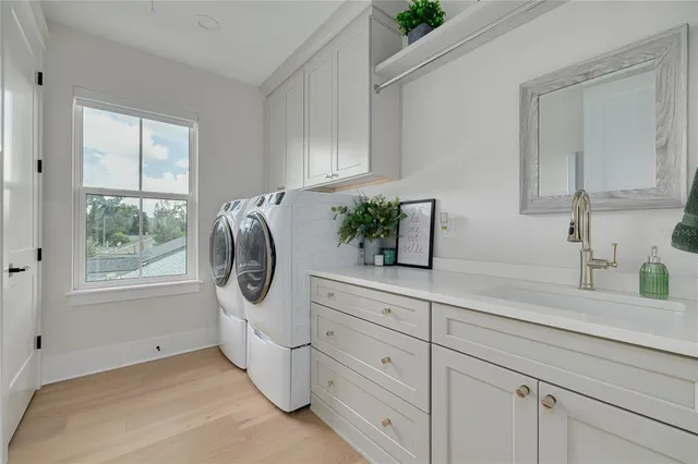 a kitchen with white cabinets and window