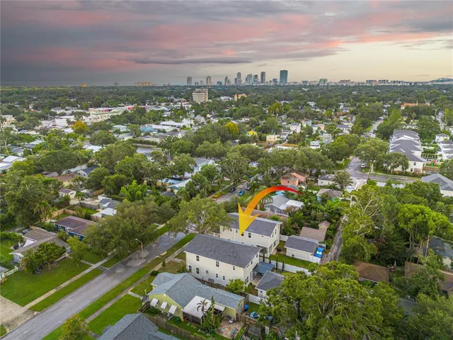 an aerial view of residential houses with outdoor space and ocean view