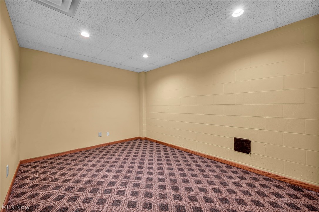 5162 Johnnycake Ridge Northeast Canton, OH 44705 - Photo 37 of 50 Spare room with dark carpet, concrete block wall, recessed lighting, and a paneled ceiling