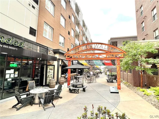 a view of a cafe with a lot of table and chairs in front of building