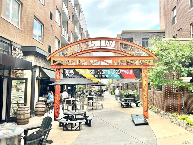 a view of path along with retail shop and large trees