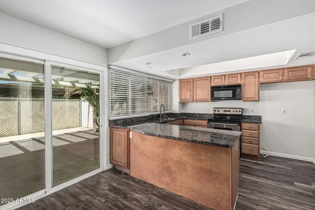 a kitchen with stainless steel appliances granite countertop a stove a sink and a refrigerator