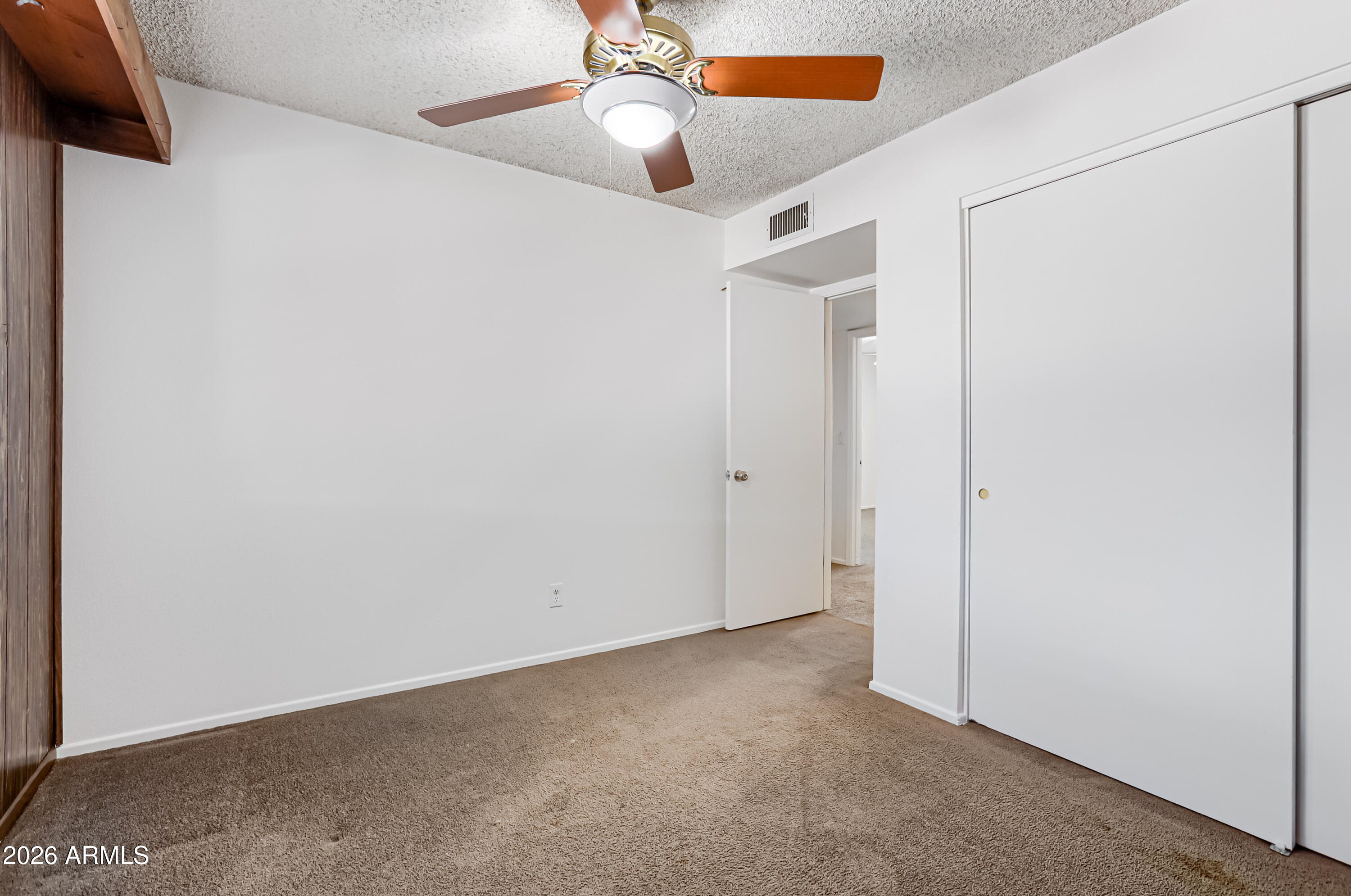 3823 West Greenway Road Phoenix, AZ 85053 - Photo 20 of 28 an empty room with closet and a chandelier fan
