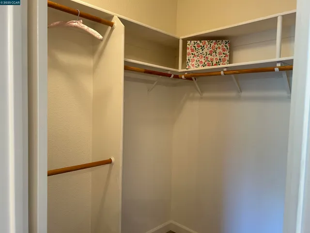 a view of walk in closet with empty racks
