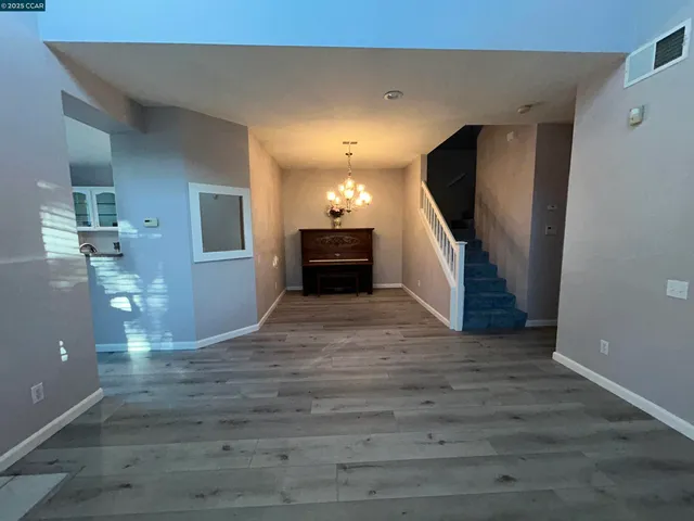 a view of a hallway with wooden floor and staircase