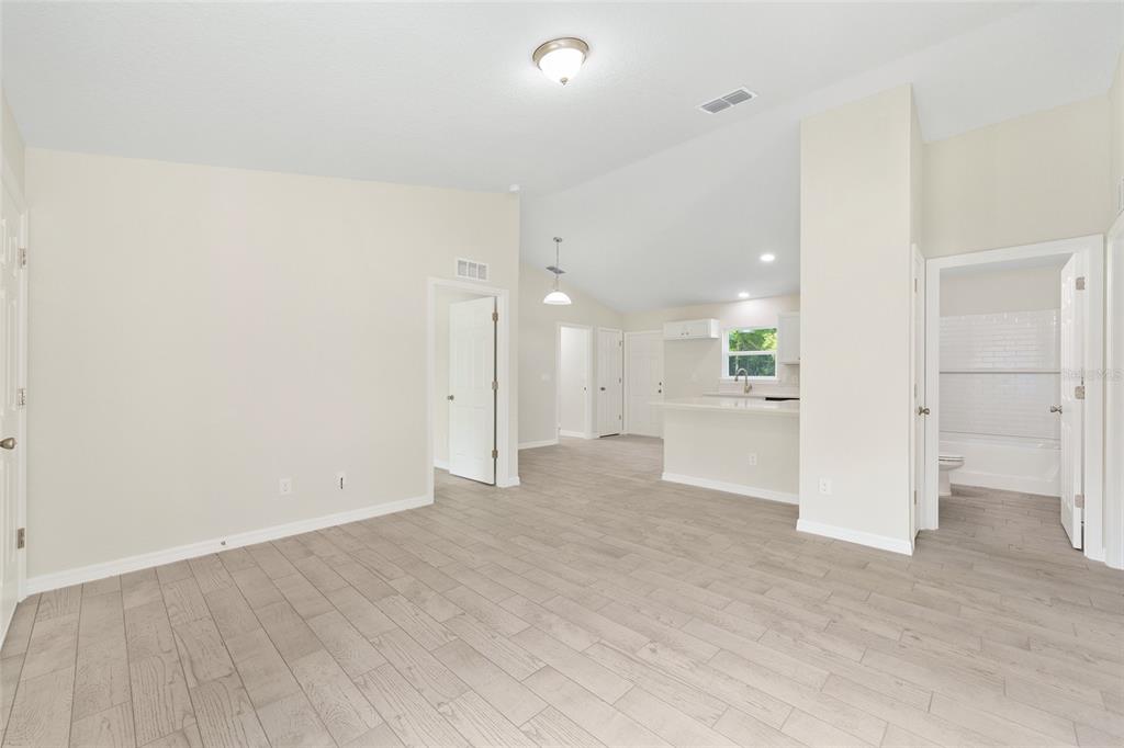 360 Locust Road Ocala, FL 34472 - Photo 13 of 48 wooden floor in an empty room with a kitchen