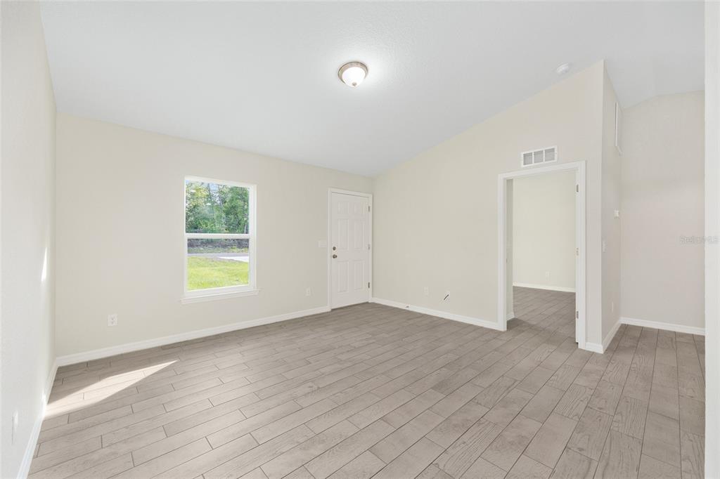 360 Locust Road Ocala, FL 34472 - Photo 14 of 48 an empty room with wooden floor and windows