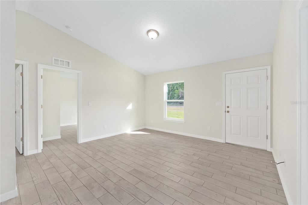 360 Locust Road Ocala, FL 34472 - Photo 15 of 48 a view of an empty room with wooden floor and a window