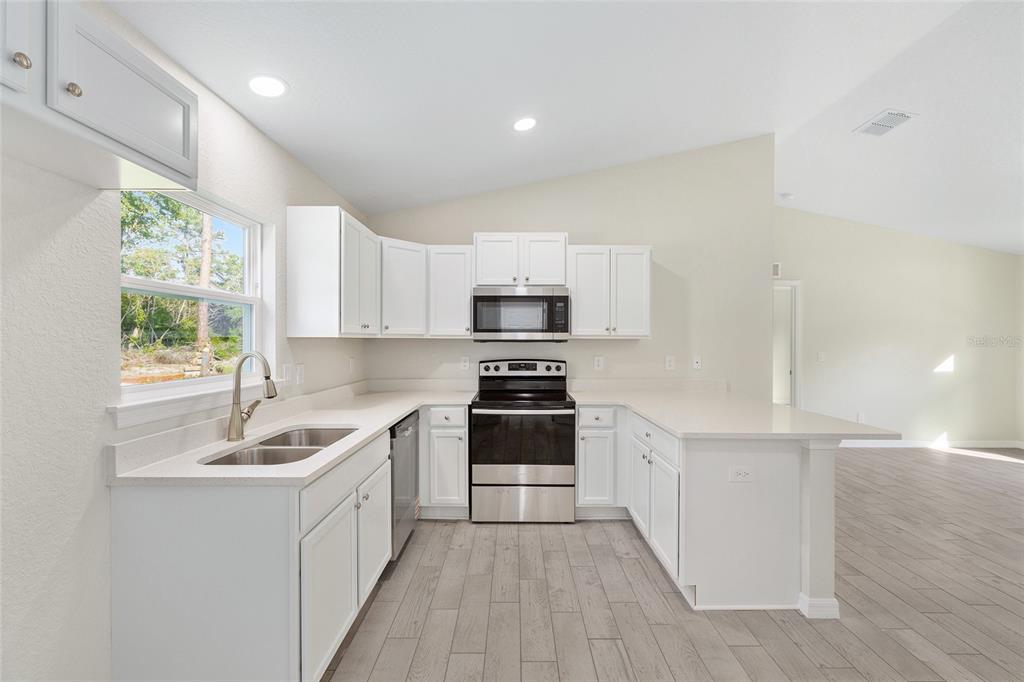 360 Locust Road Ocala, FL 34472 - Photo 19 of 48 a kitchen with stainless steel appliances granite countertop a sink stove and refrigerator