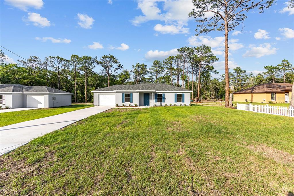 360 Locust Road Ocala, FL 34472 - Photo 2 of 48 a front view of house with yard and trees in the background