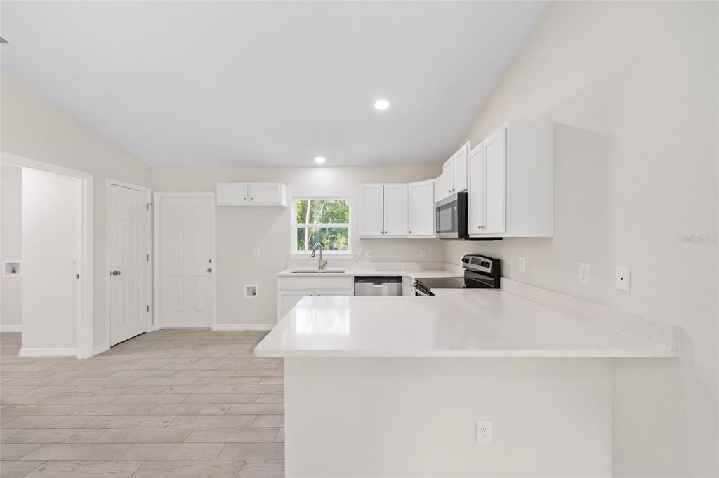 360 Locust Road Ocala, FL 34472 - Photo 21 of 48 a large white kitchen with cabinets appliances a sink and a window