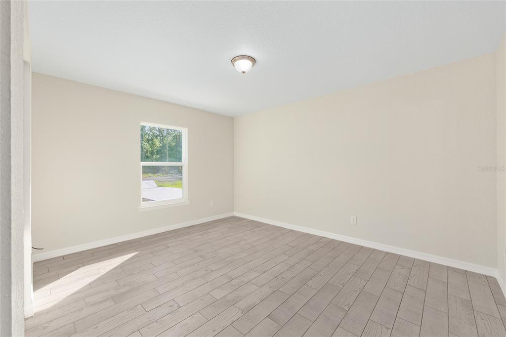 360 Locust Road Ocala, FL 34472 - Photo 23 of 48 an empty room with wooden floor and windows