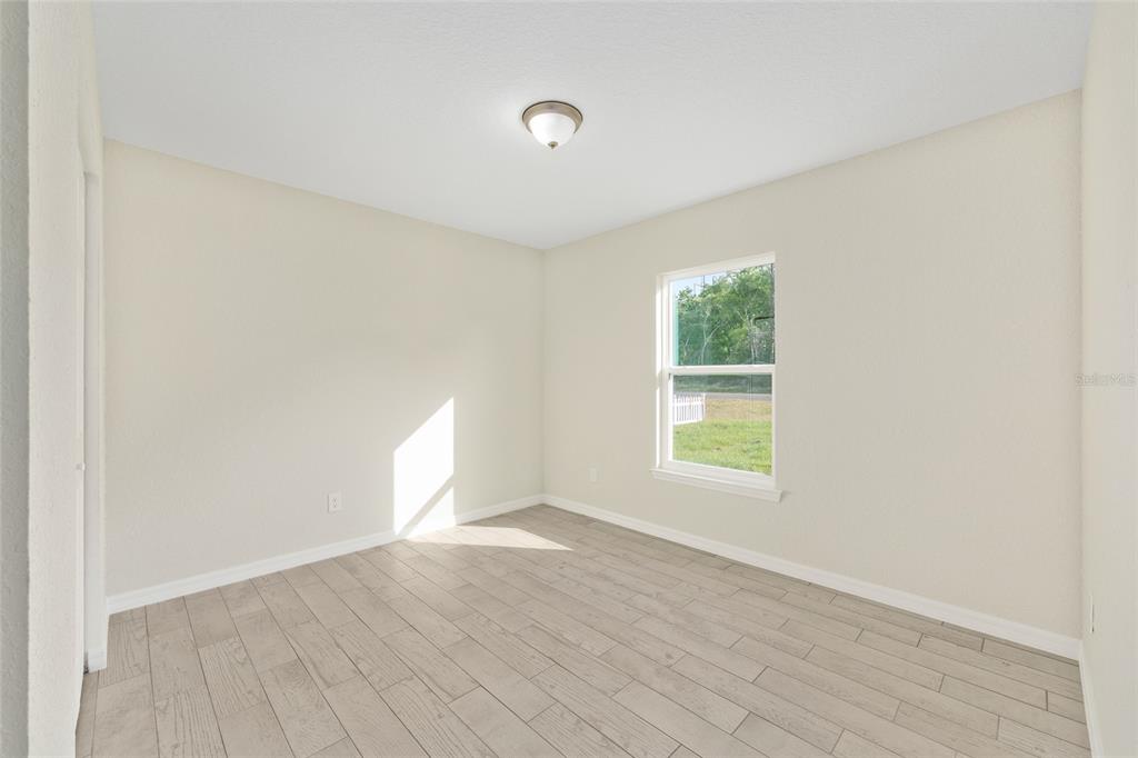 360 Locust Road Ocala, FL 34472 - Photo 26 of 48 an empty room with wooden floor and windows
