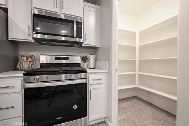 a kitchen with stainless steel appliances granite countertop a stove microwave and oven