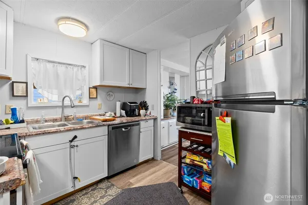 a kitchen with stainless steel appliances granite countertop a refrigerator and a sink