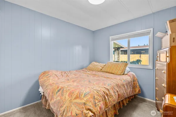 a bed sitting in a bedroom next to a window