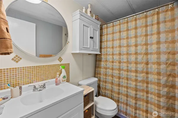 a bathroom with a sink a toilet and shower curtain