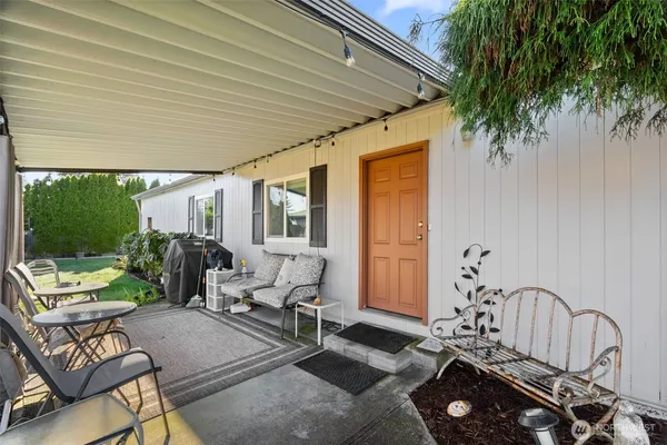 a living room with patio furniture and a floor to ceiling window