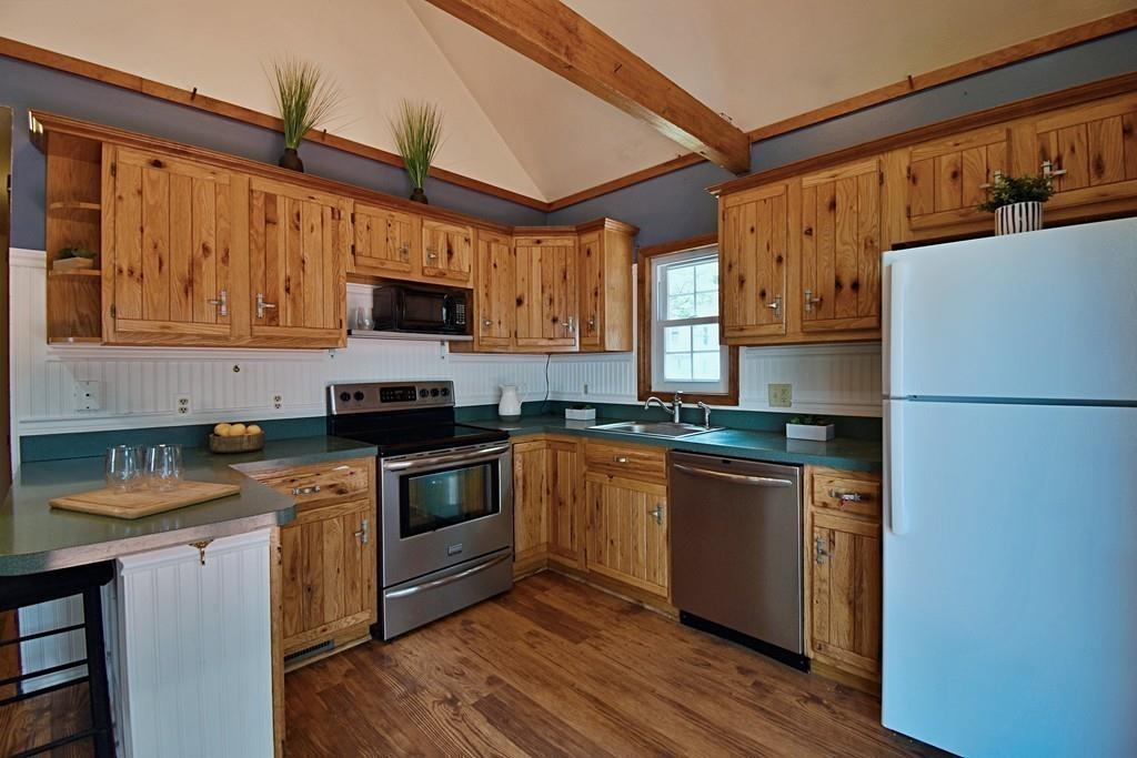16 Emeline Road Weymouth, MA 02189 - Photo 10 of 40 a kitchen with stainless steel appliances granite countertop a refrigerator a stove top oven a sink and dishwasher with wooden floor