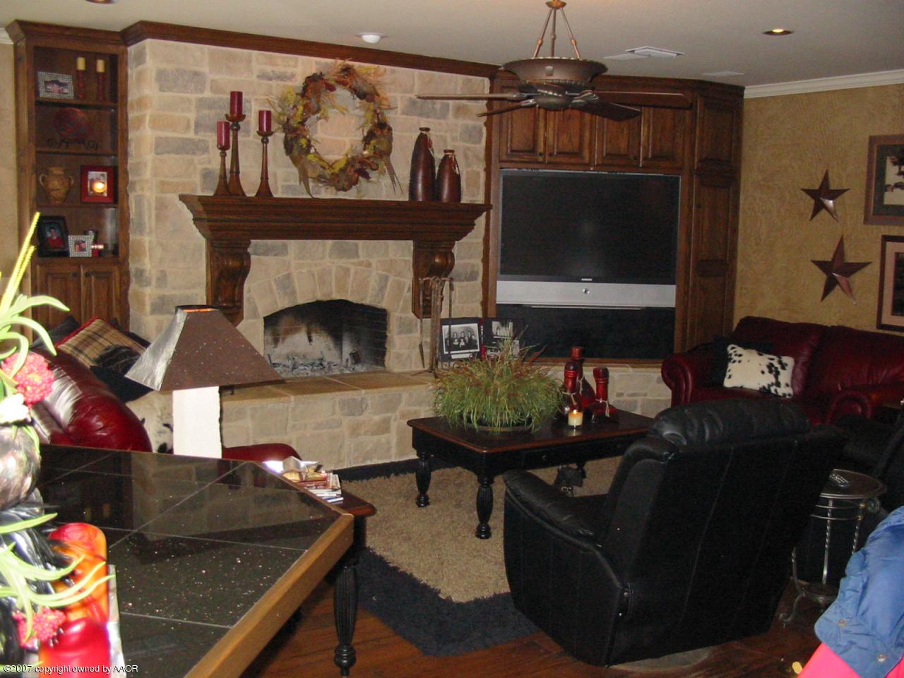 8900 Blackhawk Road Amarillo, TX 79119 - Photo 2 of 13 a living room with furniture a flat screen tv and a fireplace
