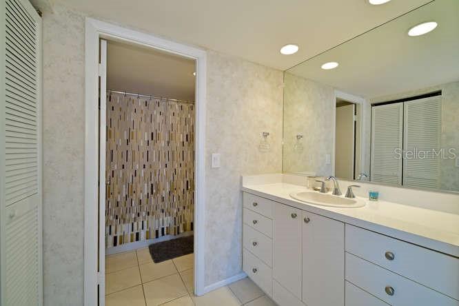 2425 Gulf Of Mexico Drive, Unit 7F Longboat Key, FL 34228 - Photo 11 of 50 a bathroom with a double vanity sink and mirror