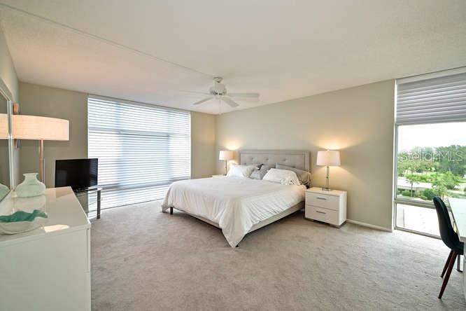 2425 Gulf Of Mexico Drive, Unit 7F Longboat Key, FL 34228 - Photo 12 of 50 a bedroom with a bed and a large window