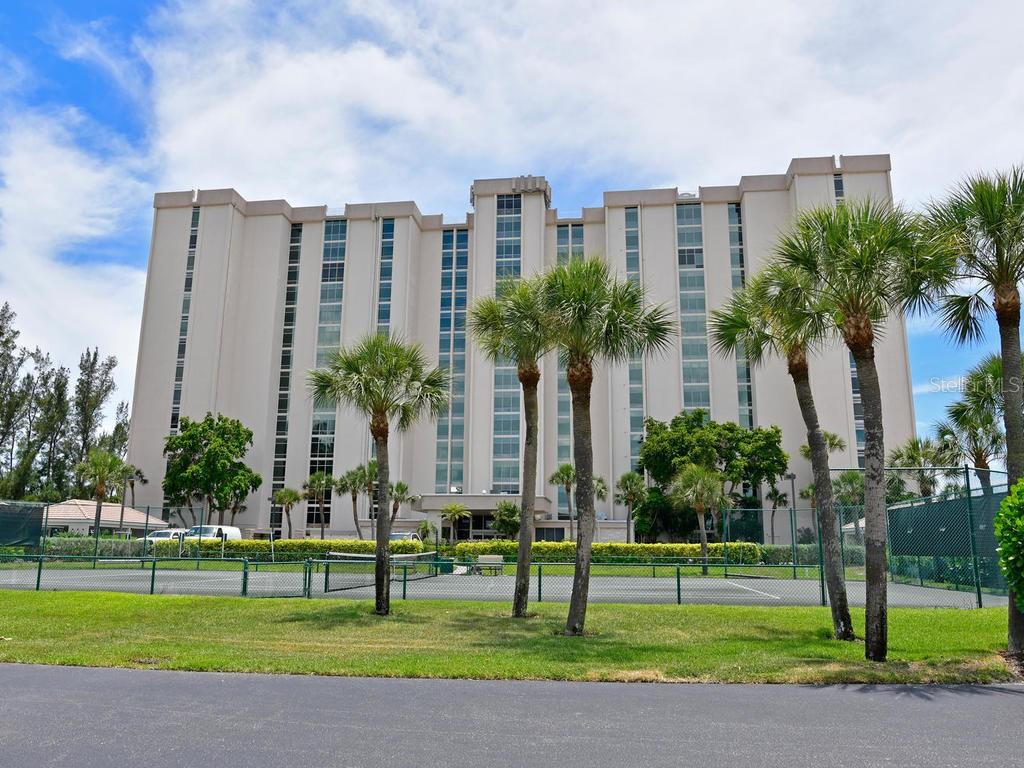 2425 Gulf Of Mexico Drive, Unit 7F Longboat Key, FL 34228 - Photo 2 of 50 a tall building with a yard in front of it