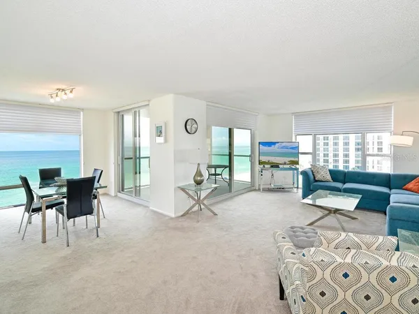a living room with furniture a dining table and a large window