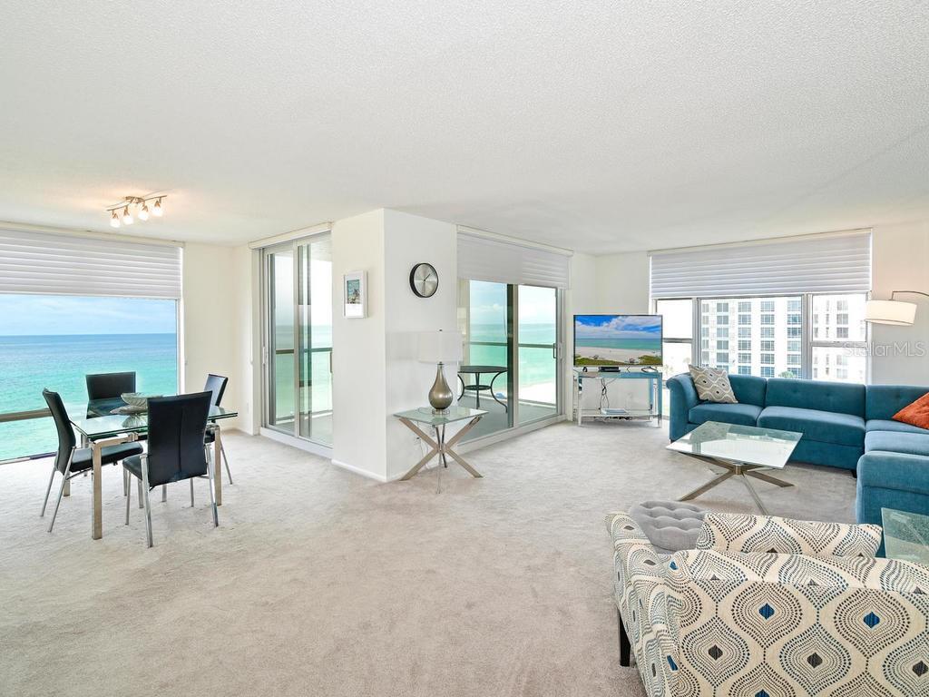 2425 Gulf Of Mexico Drive, Unit 7F Longboat Key, FL 34228 - Photo 21 of 50 a living room with furniture a dining table and a large window