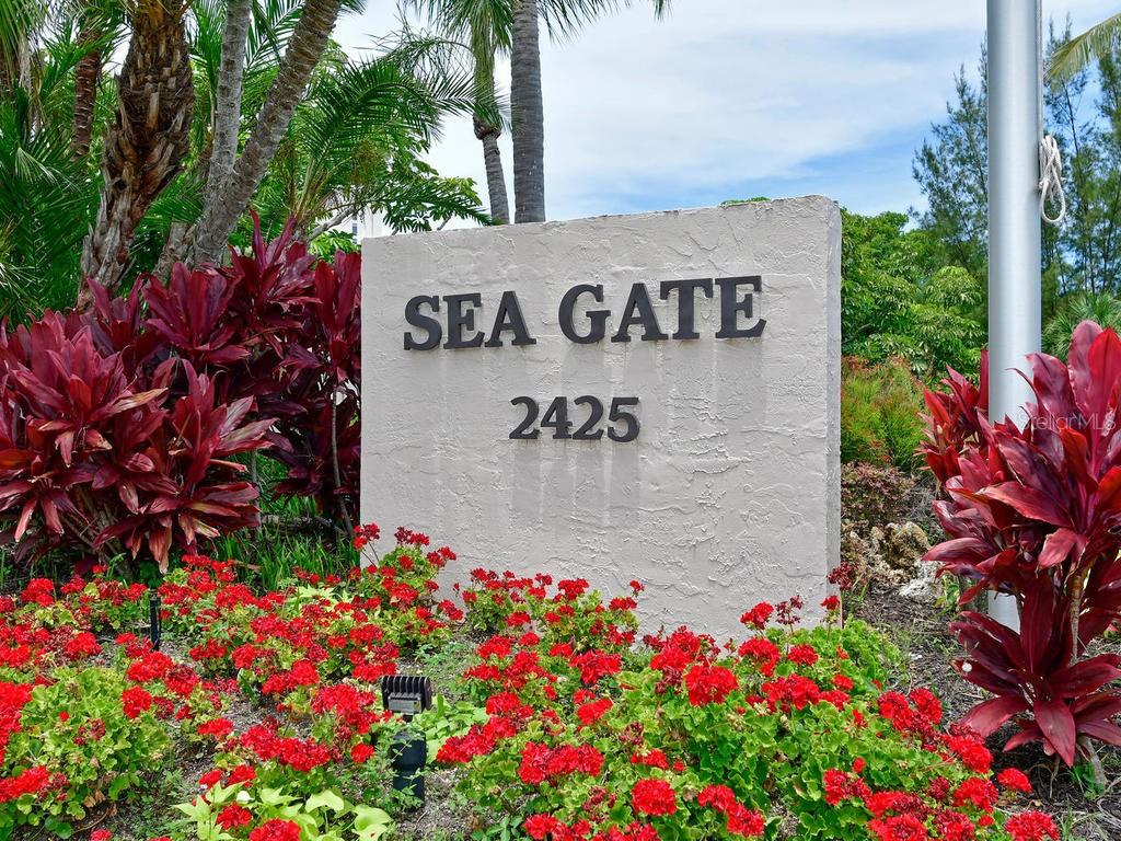 2425 Gulf Of Mexico Drive, Unit 7F Longboat Key, FL 34228 - Photo 25 of 50 a sign that is in front of flowers