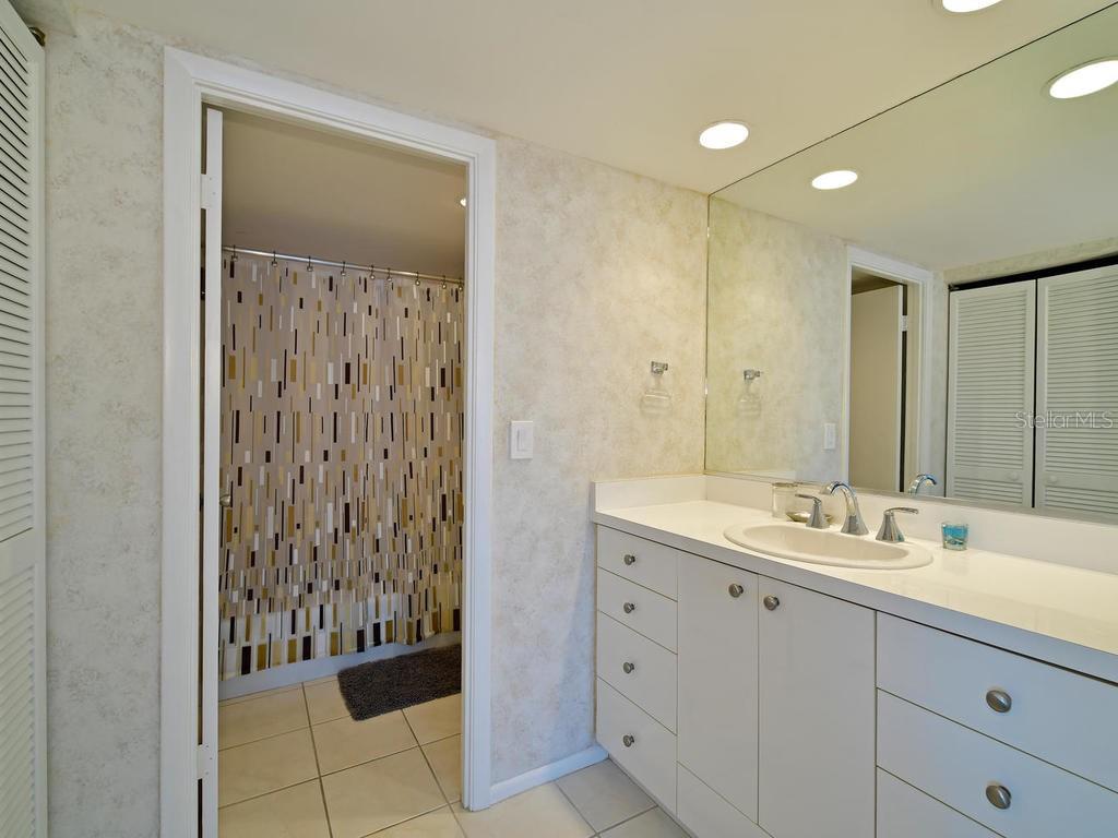 2425 Gulf Of Mexico Drive, Unit 7F Longboat Key, FL 34228 - Photo 33 of 50 a bathroom with a sink and a mirror