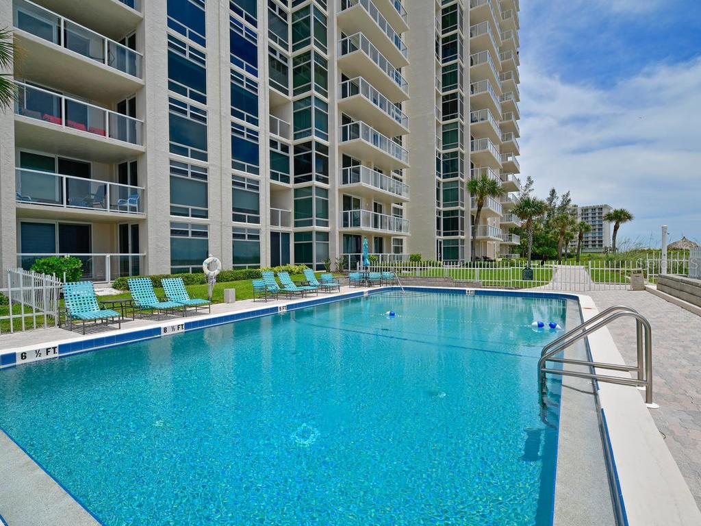 2425 Gulf Of Mexico Drive, Unit 7F Longboat Key, FL 34228 - Photo 42 of 50 a swimming pool with outdoor seating and yard