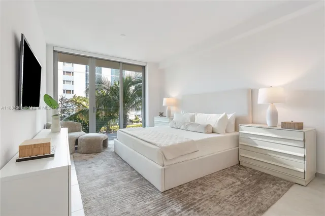 a bedroom with a bed tv and a window