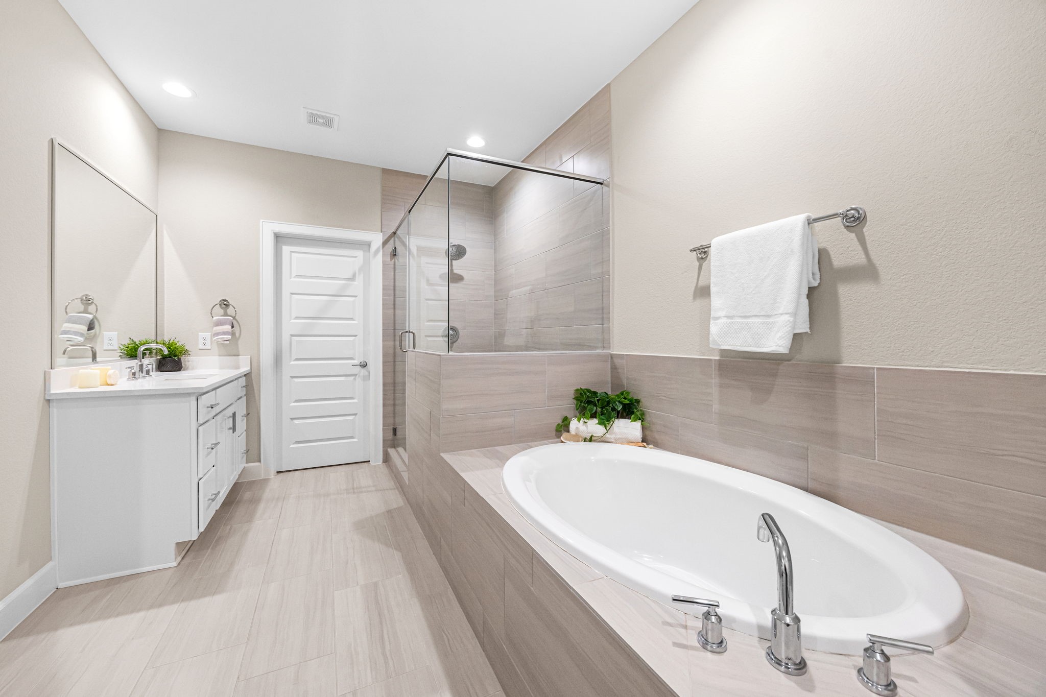 1732 Wichita Street Houston, TX 77004 - Photo 17 of 35 Spacious primary bath with dual-function layout offering a separate soaking tub and glass-enclosed shower with floor-to-ceiling tile detail.
