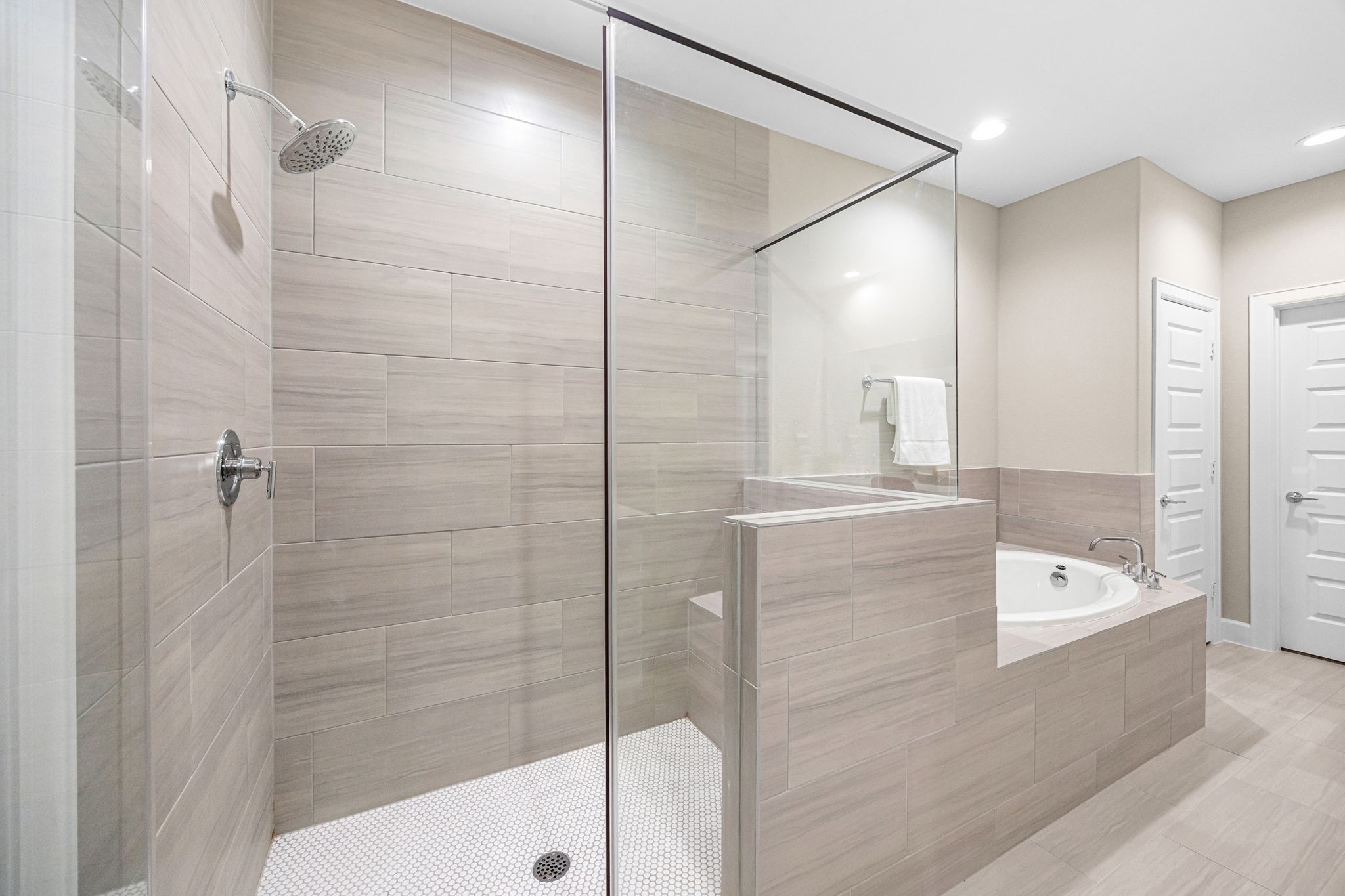 1732 Wichita Street Houston, TX 77004 - Photo 20 of 35 Spacious walk-in shower with frameless glass enclosure and modern tile surround alongside a relaxing soaking tub.