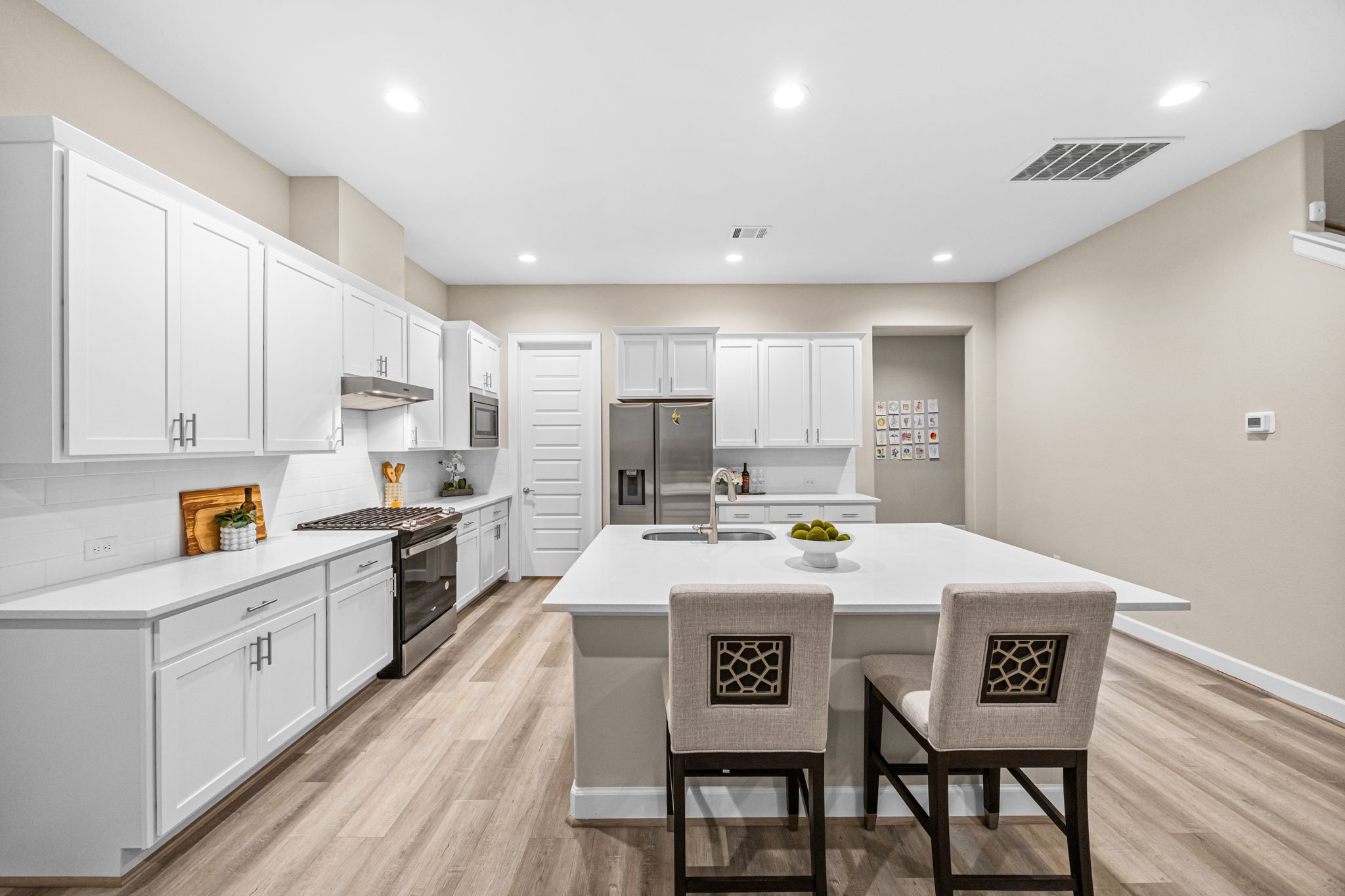 1732 Wichita Street Houston, TX 77004 - Photo 9 of 35 Bright and spacious kitchen featuring quartz countertops, oversized island with seating, stainless steel appliances, recessed lighting, and abundant cabinetry for storage.