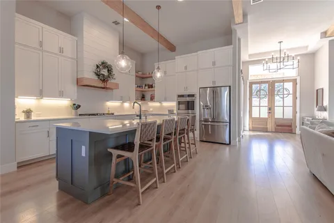 a kitchen with stainless steel appliances kitchen island granite countertop wooden floors and wooden cabinets
