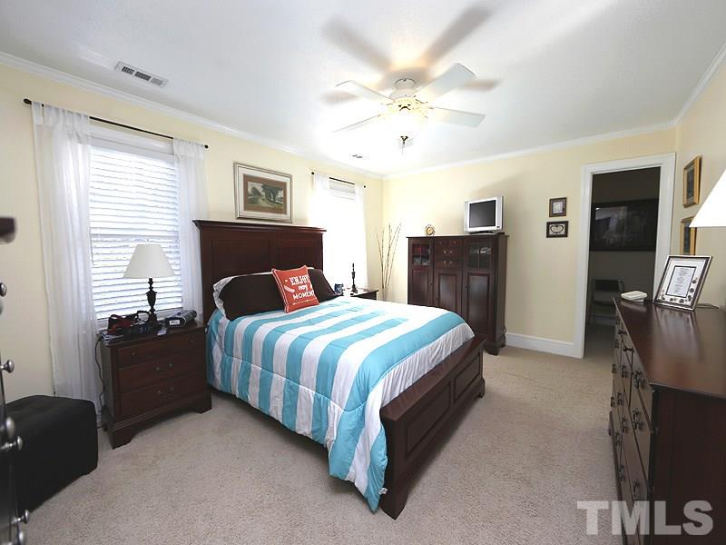 9304 Litchford Road Raleigh, NC 27615 - Photo 14 of 25 a bedroom with a large bed and flat tv screen on dresser