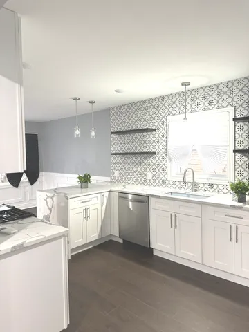 a large white kitchen with granite countertop lots of white cabinets
