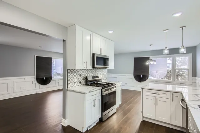 a kitchen with stainless steel appliances granite countertop a stove a sink and a microwave