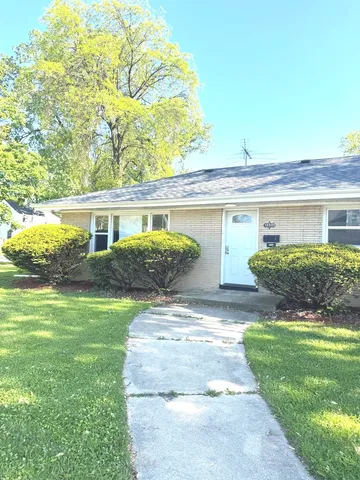 a front view of a house with a yard and potted plants